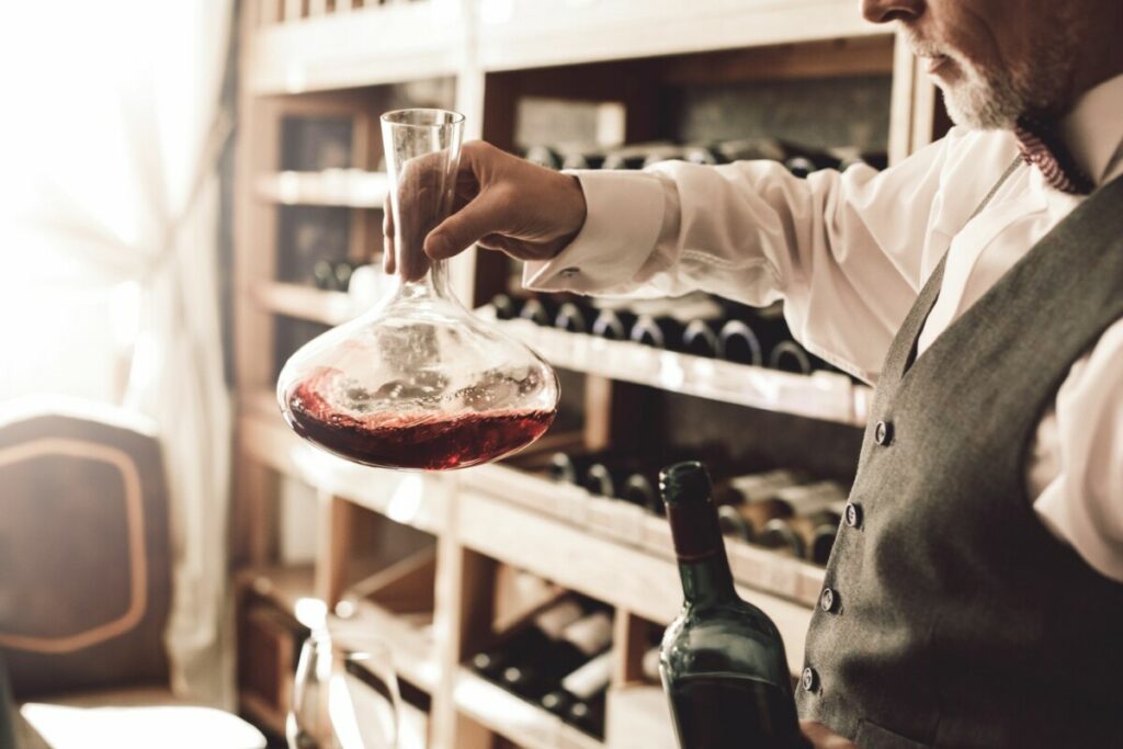 Rotwein im Dekanter wird gegen Licht auf Depot-Rückstände geprüft.